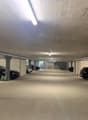 Empty parking garage with ceiling lights and pillars.