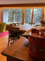 Wooden floor, dining table, chairs, TV, large glass doors, red carpet, decorative items, flowers