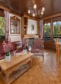 wooden floor, wooden furniture, sofa, pillows, wooden table, chairs, dining table, chandelier, wooden cabinet, window, fireplace