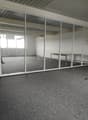 empty room, glass walls, gray floor, white walls, open door, small table, wooden shelf
