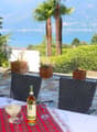 Stone floor, garden table, chairs, scenic view of mountains and lake