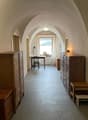 long hallway, vaulted ceiling, desk, wooden cabinet, small stool
