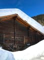 Traditional wooden house, raised ground floor, snowy roof, wooden beams, star decoration