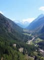 Dense coniferous forest, river, mountains, villages, clear blue sky