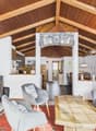 wooden ceiling, fireplace, wooden floor, gray couch, wooden coffee table, wooden chairs, wooden cabinet, basket, radiator