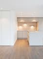 an open kitchen, central island, built-in cabinets, wooden floor, white walls, modern fixtures, an oven