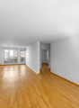 empty room with hardwood floors, large windows, balcony