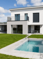 Modern 2 story white house, tiled roof, balcony, glass wall, swimming pool, grassy garden