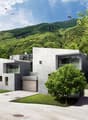 Modern concrete residential building, multiple levels, large windows, garage