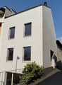 White painted house, 3 floors, 4 windows, balcony on second floor