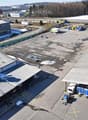 Large industrial complex with warehouses, storage facilities, and parking areas. The area appears to be used for commercial and logistical purposes.