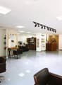 White tiled floor, white walls, modern lighting, chairs, mirrors, tables, shelves, fan, black leather furniture, wooden shelves, track lighting