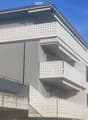 3 storey building, grey walls, balconies, modern style