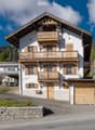 3 story house, white and brown paint, balcony, wooden garage