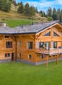wooden chalet on hill, 2 stories, large terrace with umbrella, sloping grounds, lawn