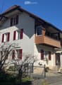 2 story house, white and brown color, red shutters, balcony, fenced yard, red rooftop