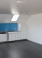kitchen area, white cabinets, blue backsplash, tiled floor, sink, dishwasher, white ceiling, two skylights