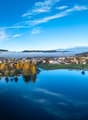Aerial view of a town with a lake, mountains, and a clear blue sky
