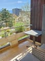 balcony with seating area, metal railing, table, chair, tile floor, view of town