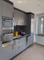 modern kitchen with gray cabinets, stainless steel appliances, and a dishwasher