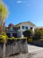 2 story house, white exterior, gray roof, 2 garages, balcony, garden