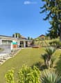 Detached house, white exterior, large garden, swing, car parked, steps leading to entrance
