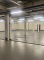 Unfurnished Room. Empty warehouse with concrete floor, white walls, and metal beams. There are no visible objects or furniture.