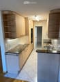 modern kitchen with granite countertops, wooden cabinets, built-in oven, double sink, and dishwasher