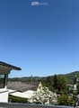 Balcony / Terrace. Balcony with a view of a suburban neighborhood, trees, and distant hills under a clear blue sky.