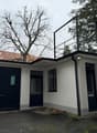 White house with garage, terrace on the top, black railings, black windows