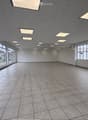 Empty room with tiled floor, large windows, and recessed lighting. No furniture or equipment present.