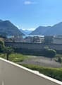 elevated view with balcony railing, mountains, city, lake