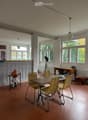 Bright, open room with large windows, wooden table, four chairs, globe on a stand, and a desk with office chair.