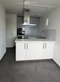Modern kitchen with white cabinets, stainless steel appliances, and a central island with a sink and faucet.
