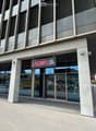 Modern commercial building entrance with large glass doors and a sign reading "LAKIMI III" above the entrance.