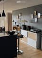 Modern kitchen with a central island, bar stools, and a sleek design. Features include a sink, pendant lights, a speaker system, and a view of the outdoor area.