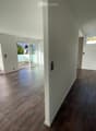 Empty room with tiled floor, white walls, and large windows leading to a balcony. The room is unfurnished and has a modern design.