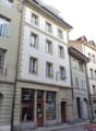 Multi-story building with classic European architecture, large windows, and a storefront at the ground level.