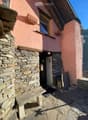 Stone wall, wooden door, window, lamp, bench, stone floor