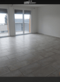 Empty room with tiled floor and large sliding glass doors leading to a balcony area.