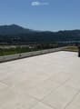 Roof terrace with tiled flooring, metal safety railing, and scenic mountain and lake view.