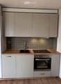 Modern kitchen with light-colored cabinets, stainless steel appliances, and wooden countertops.