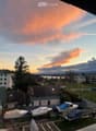Balcony view overlooking a residential area with boats on trailers, houses, and a sunset sky.