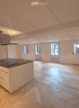 Open kitchen with island, wooden parquet floor, white walls, ceiling with recessed lighting, windows, kitchen hood, central island with sink and stove
