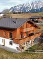 Detached house, wooden exterior, two-story, balcony, snowy mountain background