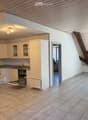 modern kitchen with white cabinets, granite countertops, dishwasher, oven, sink, wooden ceiling