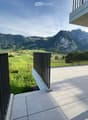 Balcony with tiled floor, wooden railing, and scenic mountain view.