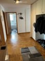 empty room with parquet floor, a closet, a bathroom, a hallway