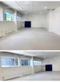 Empty room with concrete floor, white walls, large windows, and a blue door.
