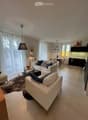 White leather sofas, beige carpet, modern glass coffee table, decorative items, table and chairs, modern kitchen set
